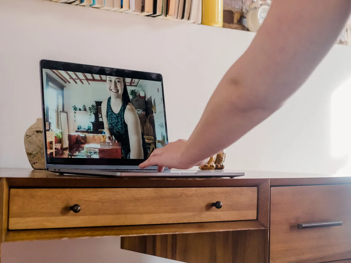 Ordinateur portable ouvert sur une table de cuisine, carnet à côté